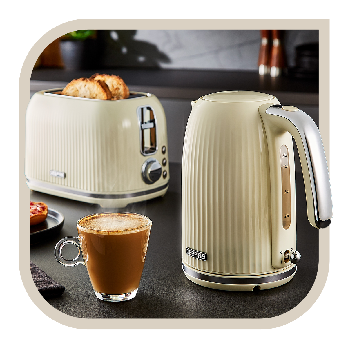 The image shows off the creme fluted matching kettle and toaster set on a kitchen countertop with some coffee and toast besides it.