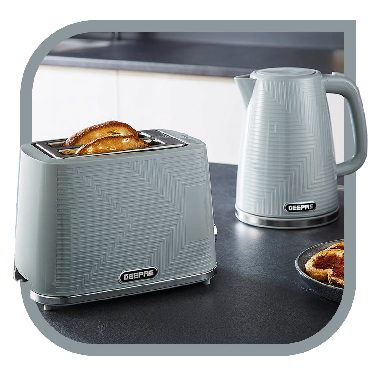 The image shows off the grey opus collection kettle and toaster matching set on top of a kitchen countertop with toast besides the toaster.