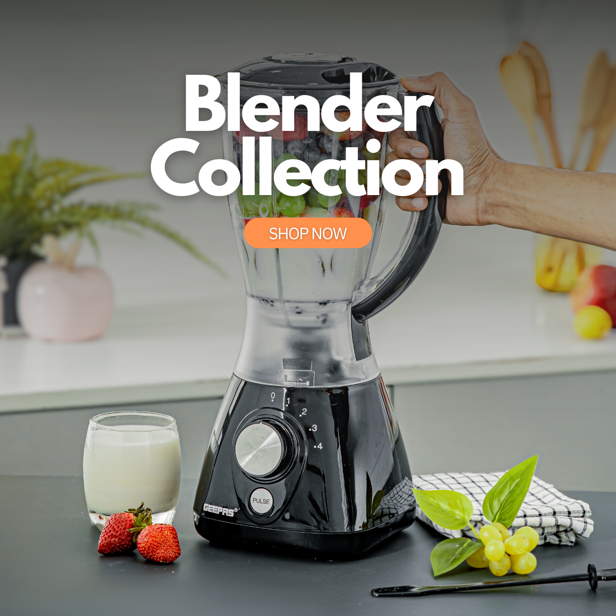 The image shows a kitchen countertop with the black basic blender on it with strawberries and grapes on the side.