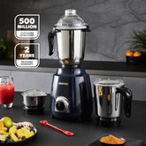 Black blender with additional jar on a kitchen counter, surrounded by fruits and drinks.
