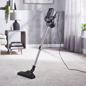 A lifestyle image of the 2-in-1 grey stick vacuum cleaner.