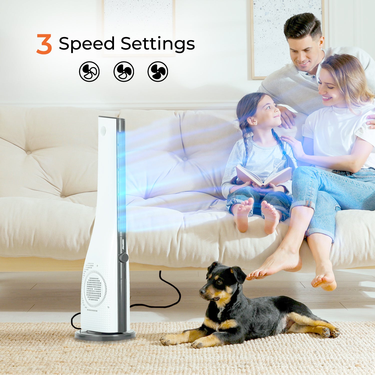This image shows the white cooling tower fan with a family sitting on a sofa besides the fan along with a puppy sitting on the carpet next to the fan.